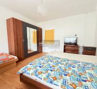 Szoba ággyal, szekrénnyel, televízióval és fa dekoros padlóval, tipikus a szállodákra és panziókra.