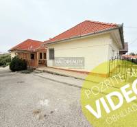 A Podhájska-i szálloda és panzió külseje terasszal, piros tetővel és zöld bokrokkal.