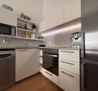 Konyha egy kétszobás lakásban, fa dekor padlóval és modern készülékekkel.