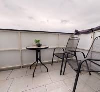 A komáromi kétszobás lakás erkélye két székkel és egy asztallal a csempén.