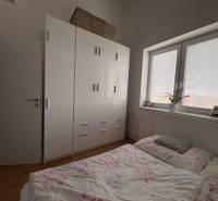 Hálószoba egy kétszobás lakásban fa dekor padlóval és nagy szekrénnyel.