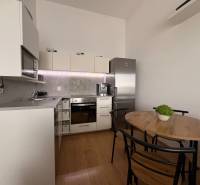 Konyha egy kétszobás lakásban fa dekoros padlóval és étkezőasztallal.