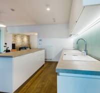 Konyha szigettel, téglafallal és fa dekoros padlóval a családi házban.