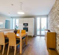 Konyha családi házban téglafallal és fa mintázatú padlóval.