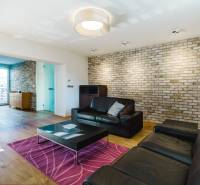 Nappali egy családi házban téglafallal és fa mintázatú padlóval.