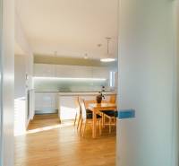 Konyha családi házban fa mintázatú padlóval és étkezőasztallal.