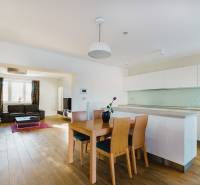 Konyha és nappali családi házban, fa hatású padlóval és világos bútorokkal.