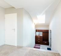 Családi ház belső tere járólappal és fehér falakkal, lépcsőház és tetőablak.