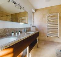 Fürdőszoba családi házban kőmosdóval, tükörrel és nagy ablakkal.