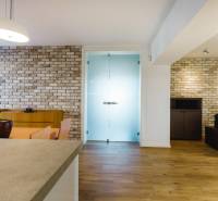 Családi ház étkezője téglafallal és fa dekorációjú padlóval.