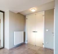 Minimalista dizájnú előszoba egy családi házban, tükörrel és világos falakkal.