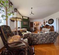 Nappali egy öt vagy több szobás lakásban, fa dekoros padlóval és vintage bútorokkal.