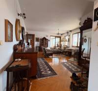 Öt vagy több szobás lakás fa dekor padlóval, klasszikus bútorokkal és szőnyegekkel.