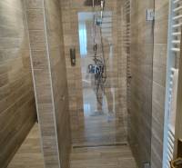 Zuhanykabin kerámia burkolattal és fa dekorációjú padlóval a faházban.