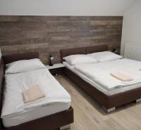 Kétágyas szoba faházban, fa dekoros padlóval és fa burkolattal.