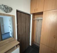 Előszoba tárolóhelyekkel egy háromszobás lakásban, fa dekoros padlóval.