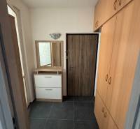 Folyosó sötét csempével és beépített szekrénnyel egy háromszobás lakásban.