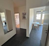 Folyosó sötét csempével és étkezővel egy 3 szobás lakásban.