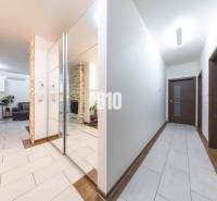 Családi ház folyosója csempével és tükrös fallal.