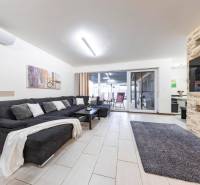 Nappali egy családi házban kanapéval, kandallóval és tolóajtókkal a teraszra.