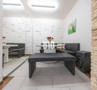 Családi ház belső tere ülőhellyel, tükrös fallal és dekoratív burkolattal.