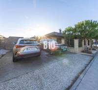 A pozsonypüspöki családi ház udvara parkolóhelyekkel és parkoló autókkal.