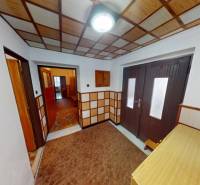 Folyosó egy családi házban, fa dekorációval burkolt falak és padló.