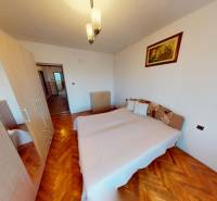 Hálószoba ággyal, szekrénnyel és fa dekorációjú padlóval egy családi házban.