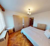 Hálószoba családi házban ággyal és szekrénnyel, fa dekoros padlóval.