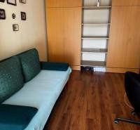 Szoba egy háromszobás lakásban fa dekor padlóval és beépített szekrényekkel.