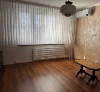 Szoba fa dekorációs padlóval és asztallal egy háromszobás lakásban.