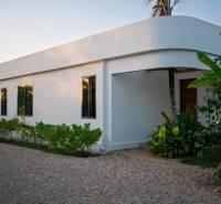 Házak építése Paje-ben, Unguja déli régiójában, zöld területtel a fehér épület körül.