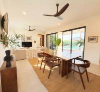 Belső tér étkezőasztallal, fa dekorációjú padlóval és nagy üvegajtókkal, házépítés.