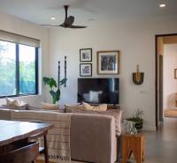 Belső tér kanapéval, televízióval és fa bútorokkal egy épülő házban.