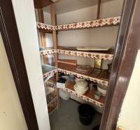 Kamra egy háromszobás lakásban beépített polcokkal és tárolt konyhai eszközökkel.