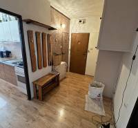 3 szobás lakás belső tere fa dekor padlóval és fali fogassal.