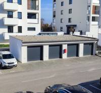 Kilátás a trenčíni Predmerského utcára, lakóházzal és parkolóval.