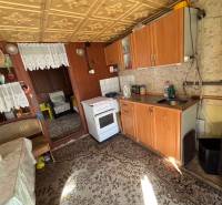 Konyha fa dekorációval, kanapéval és szőnyeggel a kertben.