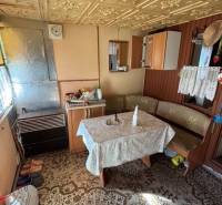 Ház belső antik mintás asztallal és fa részletekkel a kertekben.