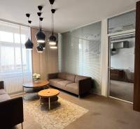 Irodák kényelmes kanapékkal, kerek asztallal és érdekes mennyezeti világítással.