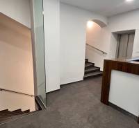 Irodák recepcióval, lépcsőház, fa dekorációjú padló.