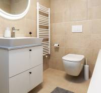 Fürdőszoba egy egyszobás lakásban mosdószekrénnyel, WC-vel és káddal.