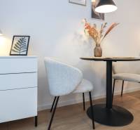 1 szobás lakás dekoratív székekkel, asztallal és lámpával, fa dekorációjú padlón.