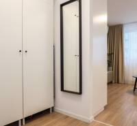 Bútor egy egyszobás lakásban fa dekor padlóval és fekete asztallal.