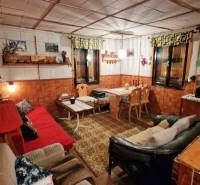 Rusztikus belső tér a házikóban kanapékkal, fa dekorációval és díszítésekkel, otthonos hangulatban.