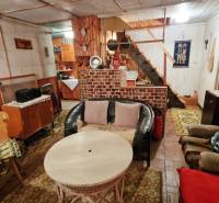 Házikó rusztikus bútorokkal és kényelmes ülőhellyel, fa dekorációjú padlóval.