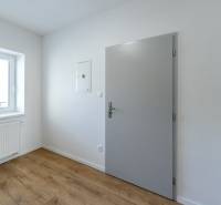 Szoba belső tér fehér falakkal, fa dekoros padlóval és ablakkal.