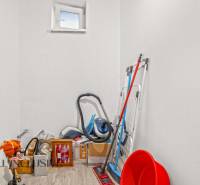 Tárolóhely tisztítószerekkel és fa dekorációjú padlóval egy családi házban.