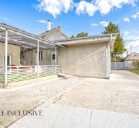 Családi ház Nagykosihán: beton terasz, előtető, kert, kék égbolt.