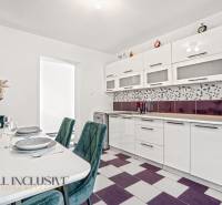 Családi ház konyhája beépített készülékekkel és geometrikus csempével.